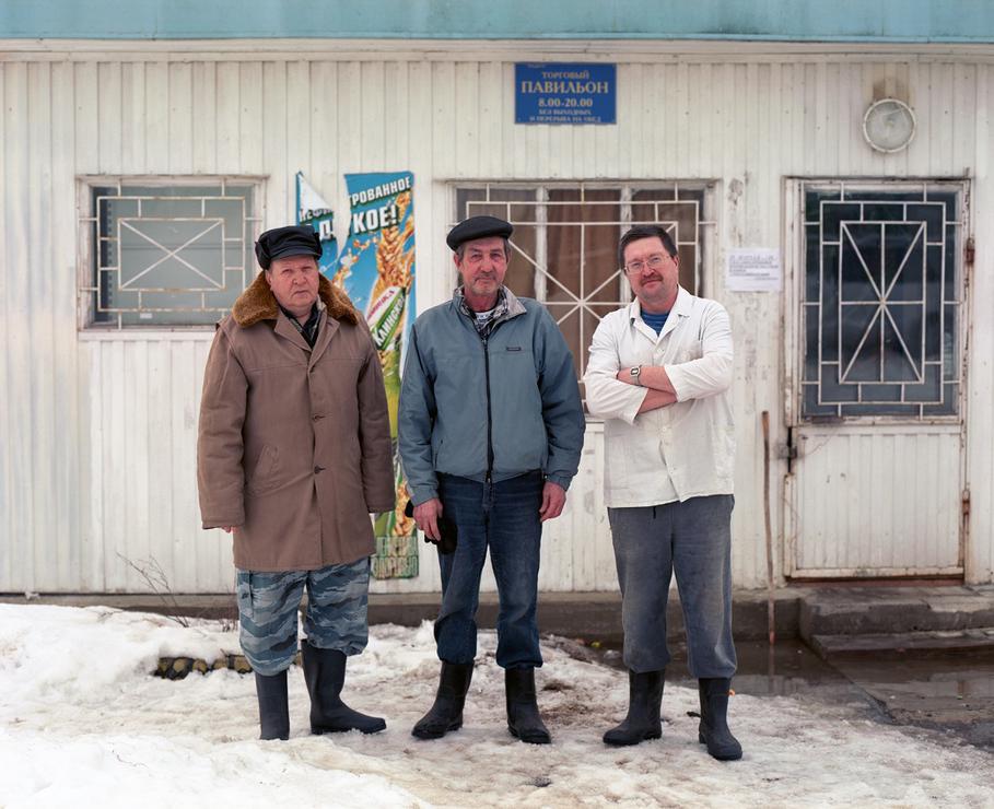 Trois hommes devant une épicerie de village